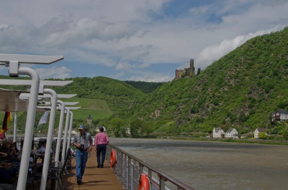 This picture shows passengers up on the sun deck (in the shade and out of the wind, on the left side) as we cruised down the Rhine looking at castles,like the one on the right.
